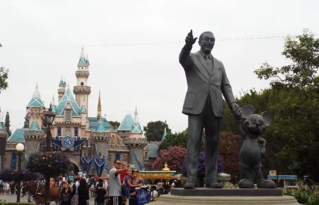The Statue of Walt Disney and Mickey Mouse in Disney Land California withe Magic Castle in the background