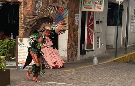 A Native Mexican dances in the streets of Puerta Vallarta dressed in traditional clothing and feathered headwear