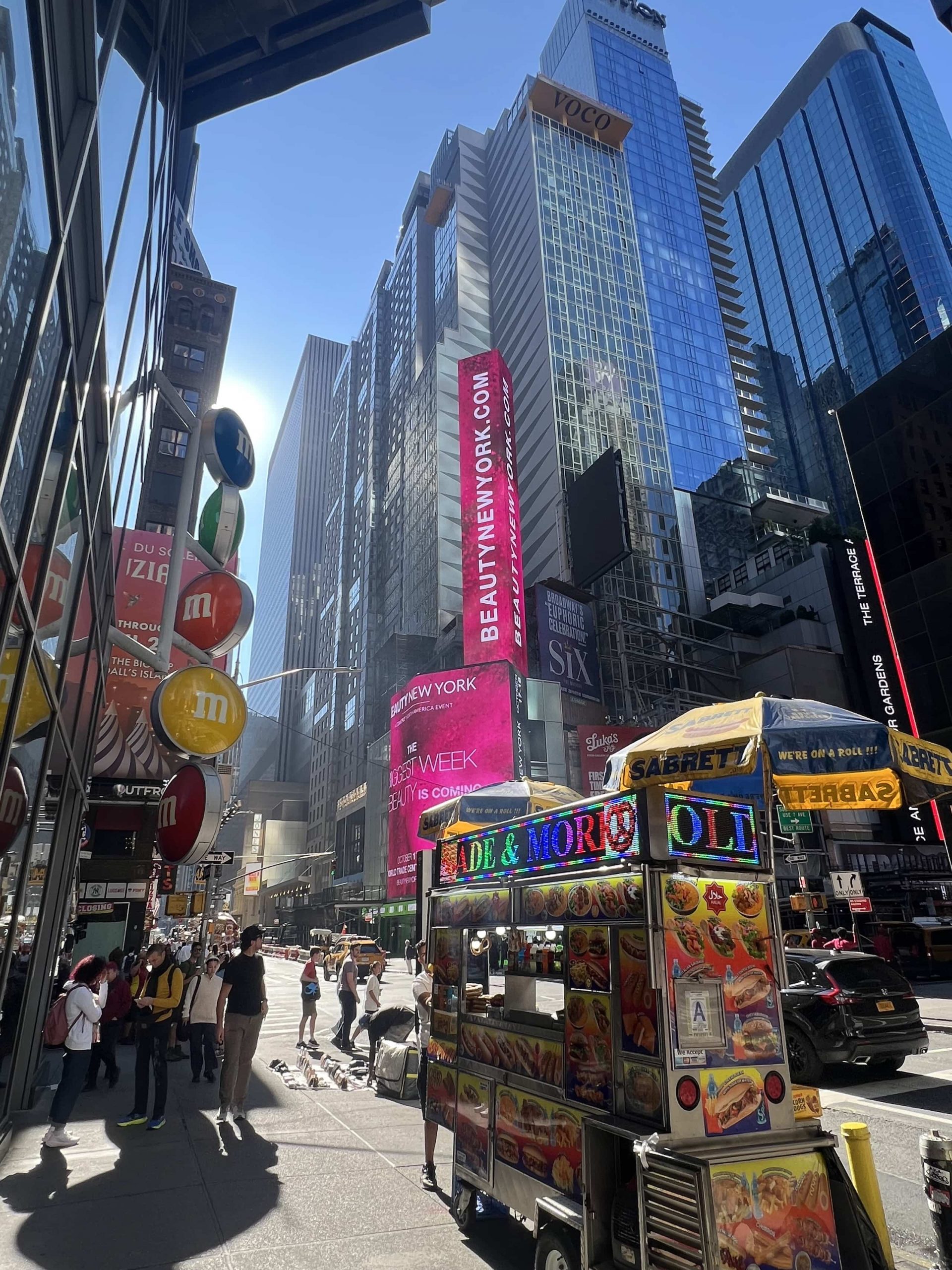 East_Coast_Roadtrip_New_York_Ithaca_00016 Glass sky scrapers in New York shimmering in the sun with hot dog carts in the foreground