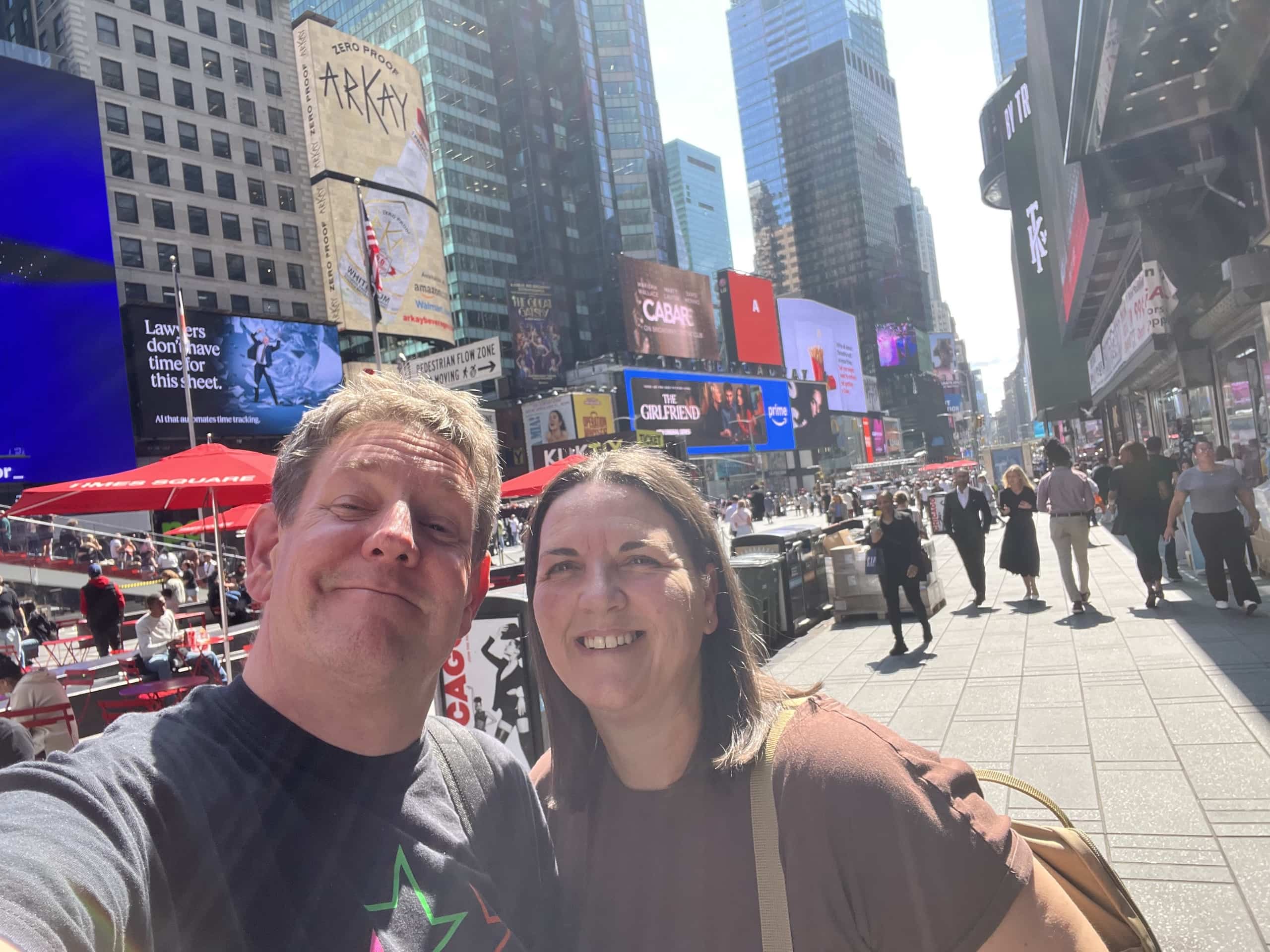 East_Coast_Roadtrip_New_York_b00003 Two people taking a selfy with a back drop of sky scrapers in Times Square New York NYC
