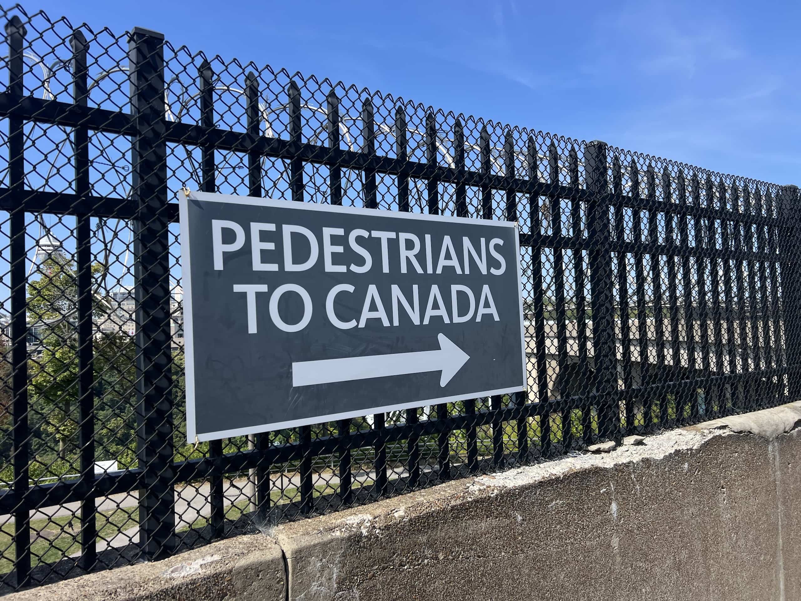 East_Coast_Roadtrip_Niagara_00009 a sign saying Pedestrians to Canada and an arrow located on the Rainbow bridge between America and Canada