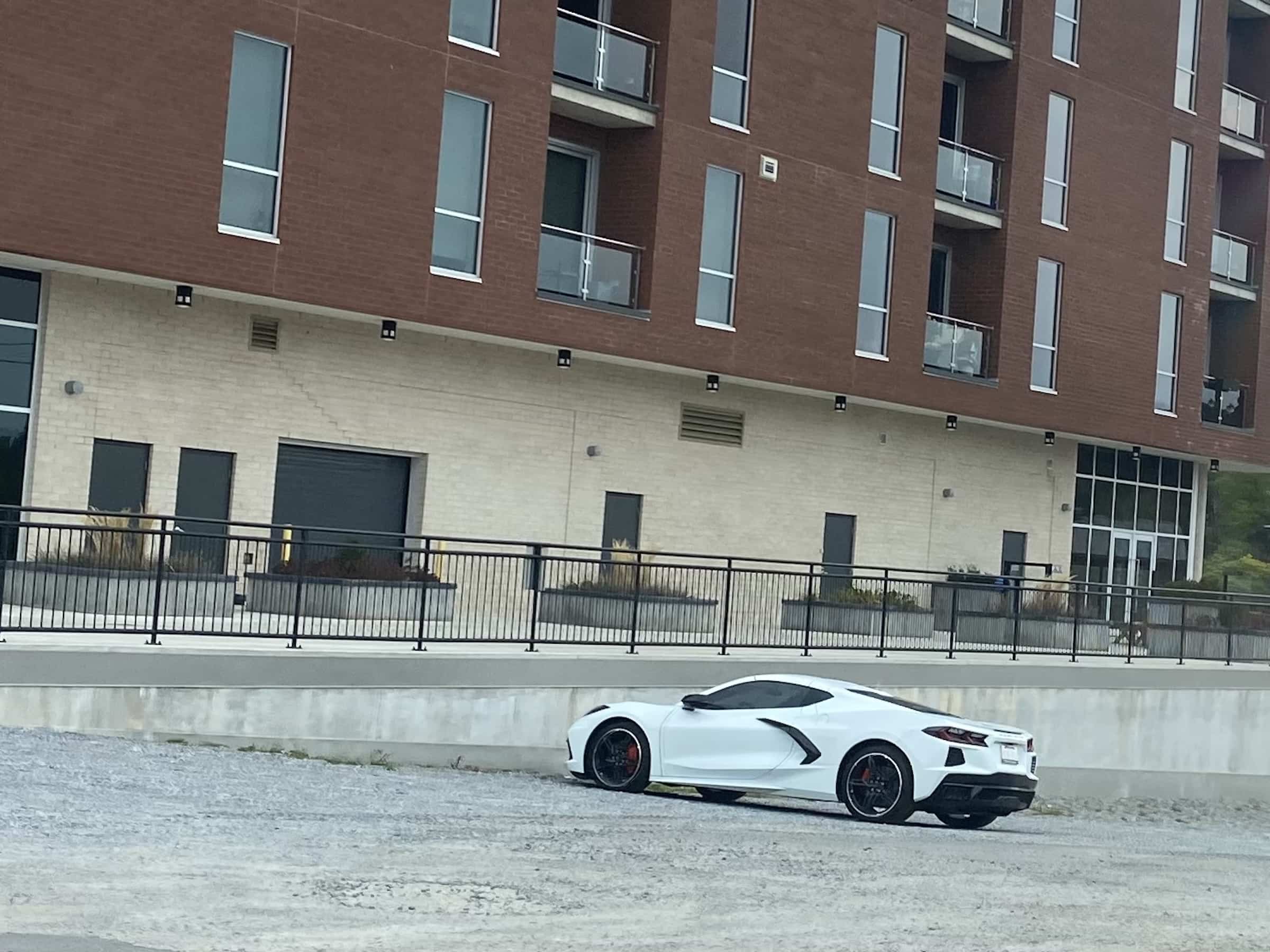 East_Coast_Roadtrip_views_from_passenger_side_gallery_01-00035 A white sports car parked in front of a red brick condo