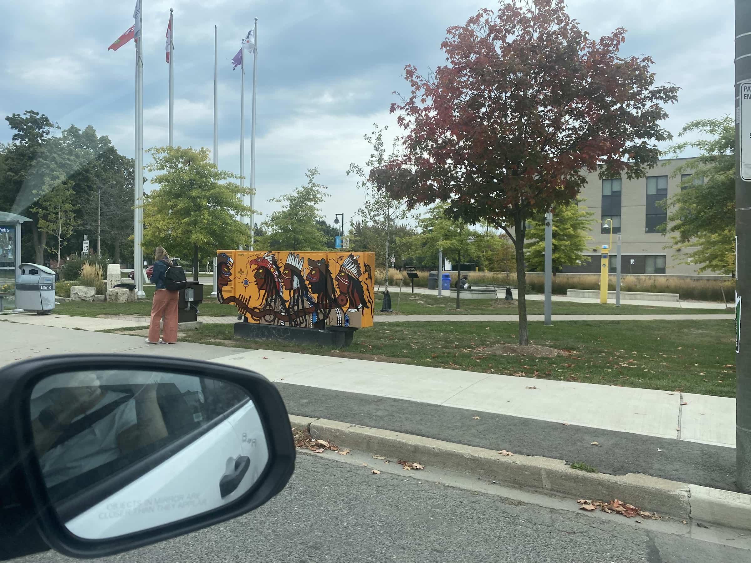 East_Coast_Roadtrip_views_from_passenger_side_gallery_01-00039 Graffiti at the side of the road driving through Canada featuring cartoon Red indians with feathers head dresses on a bright yellow background